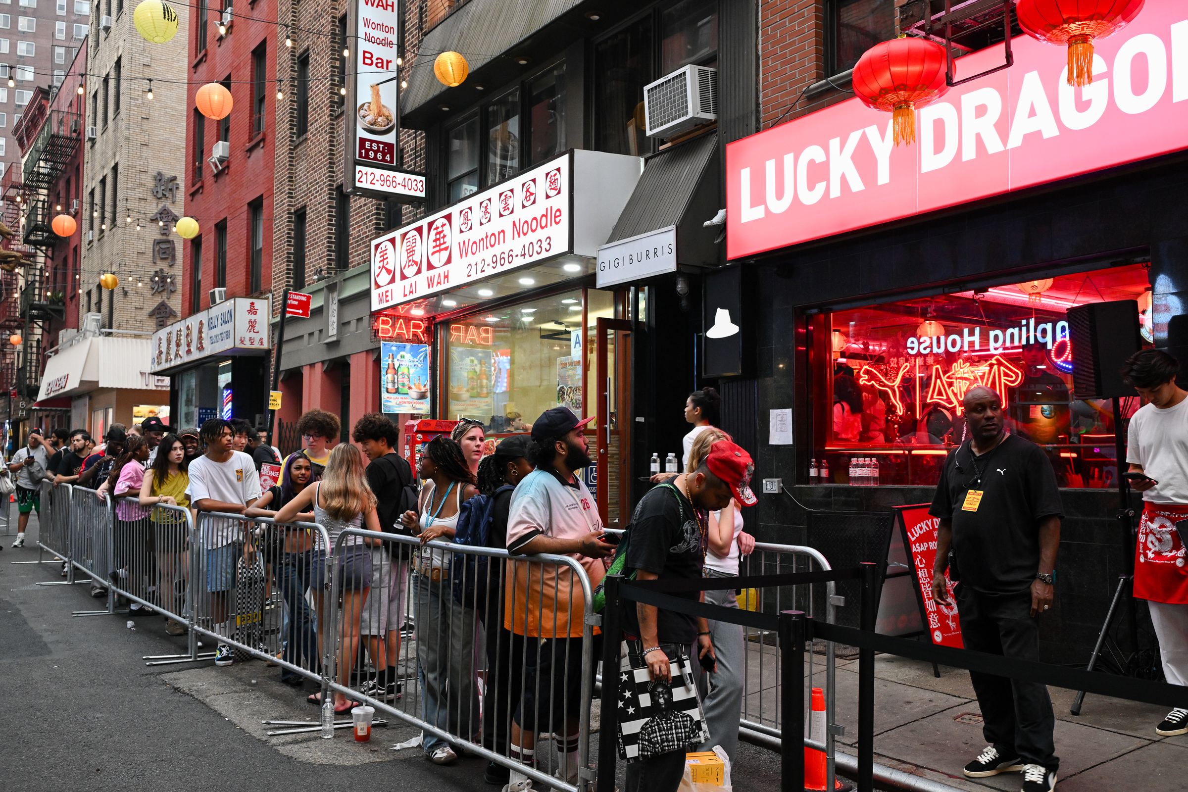Fans lined up behind barricades down Pell Street under the LUCKY DRAGON neon sign