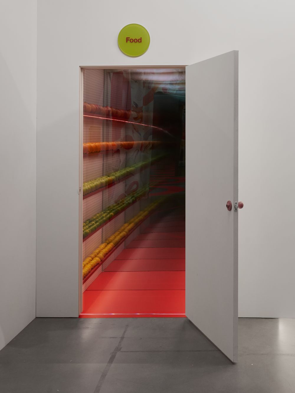 An open door revealing a long corridor of grocery shelves