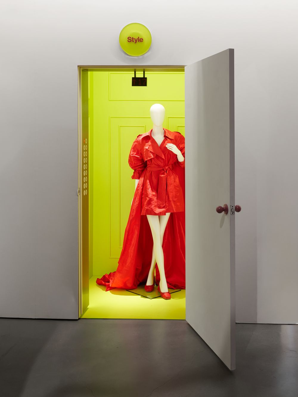 An open door revealing a red gown in a lime-green room
