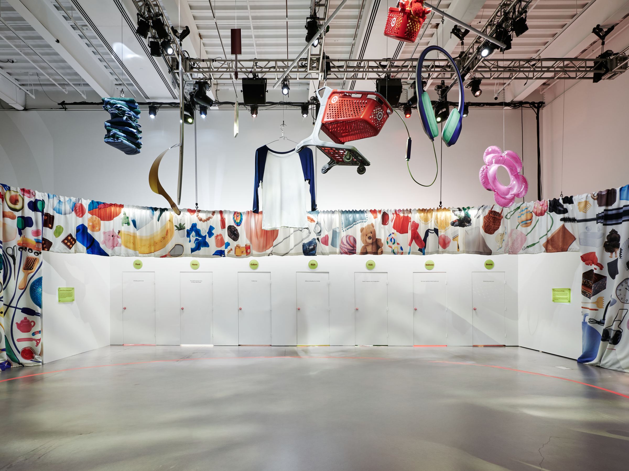 A gallery at the New Museum hung with oversized Target objects above a row of seven doors